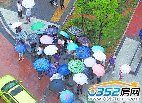 居民打傘圍在西韓新苑西門(mén)口